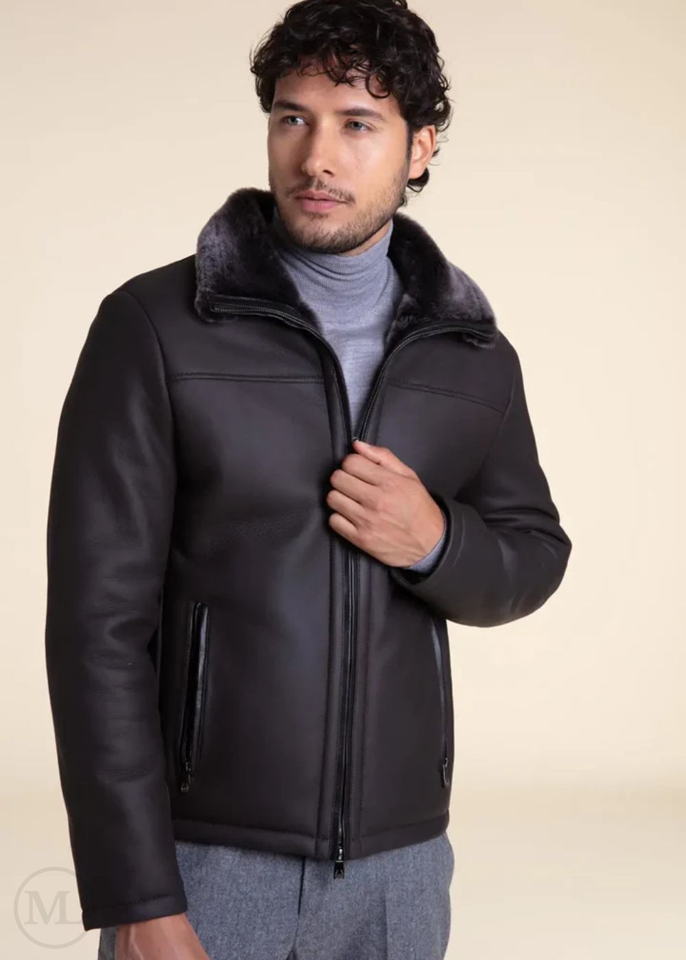 Man wearing a dark grey leather jacket with fur collar on a beige background
