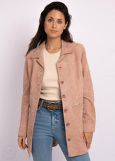 Woman wearing a pink laether coat, beige sweater, and blue jeans on a white background