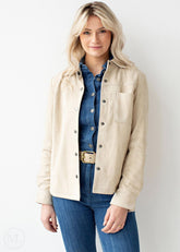 Woman wearing a off white jacket over a denim shirt and jeans on a white background