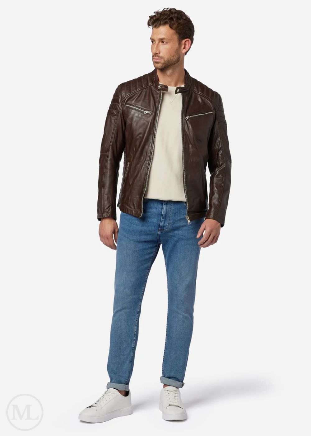 Man wearing a brown leather biker jacket, white shirt, blue jeans, and white sneakers on a white background